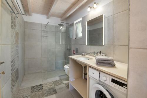 a bathroom with a sink and a washing machine at Amaranthus house in Longós