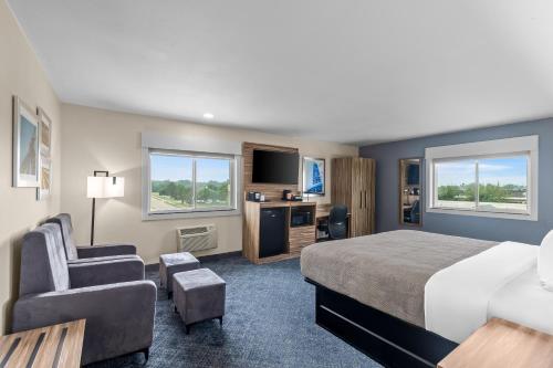 a large hotel room with a bed and a chair at Quality Inn Ponca City in Ponca City