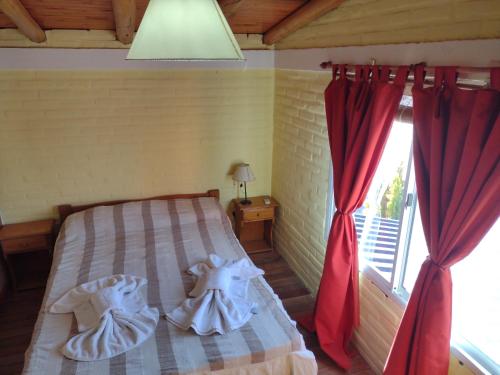 a bedroom with a bed with two dresses on it at Cabañas Mi Atardecer in Nono