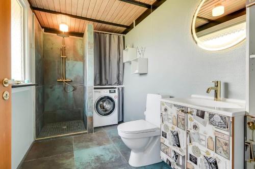 a bathroom with a toilet and a washing machine at C11704-Hemmet-Rylevaenget-33 in Hemmet