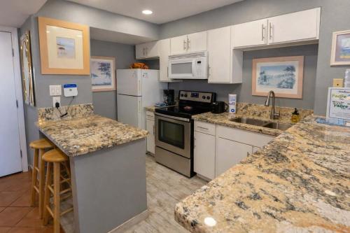 a kitchen with white appliances and granite counter tops at EZ Beach Access Great Family Condo SpaceX view in South Padre Island