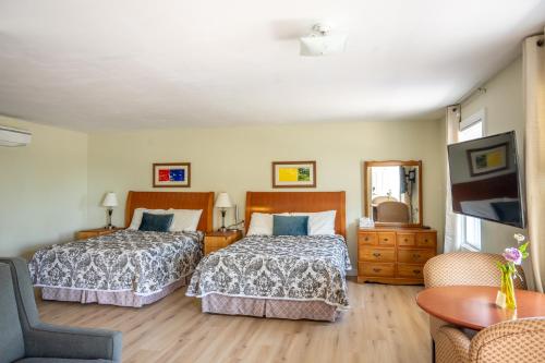 a hotel room with two beds and a television at Bouctouche Bay Inn in Bouctouche