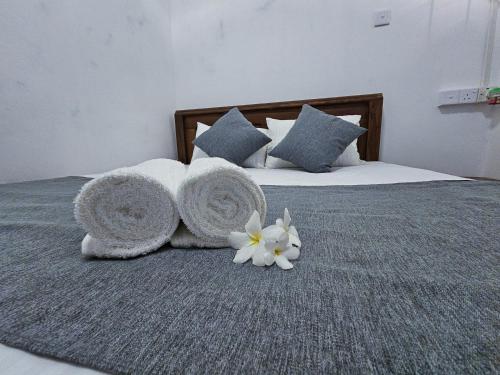 a bed with towels and flowers on top of it at Casa Cayena - Tangalle in Tangalle