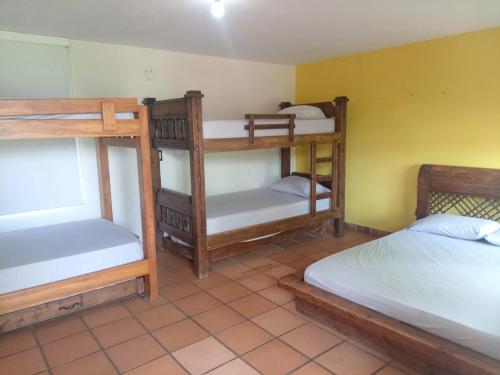 a room with three bunk beds in a room at Finca Los Pony Girardota Antioquia in Girardota