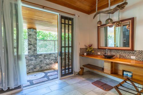 a bathroom with a shower and a sink and a mirror at Our Beachfront Bungalow in Puerto Viejo