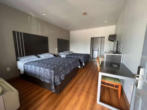 a hotel room with two beds and a desk with a computer at Century Inn in Dallas