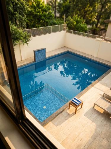a swimming pool seen through a window at Morjim Pride Hotel with Swimming Pool near Morjim Beach in Morjim