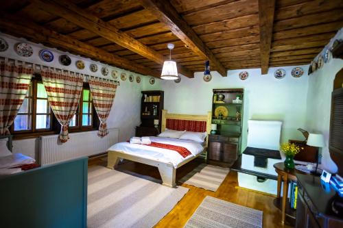 a bedroom with a bed and a wooden ceiling at DejaView Casa Veche in Rogojel