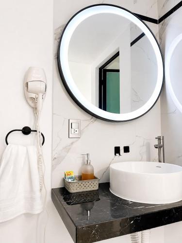 a bathroom with a sink and a mirror at La Palma Coliving in San Lucas Xoloc