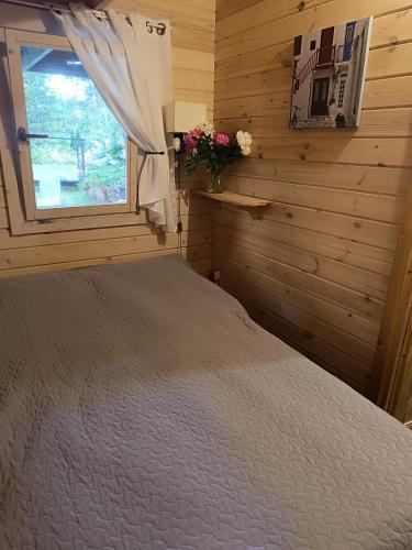 a bedroom with a bed and a window at domik in Lapmežciems