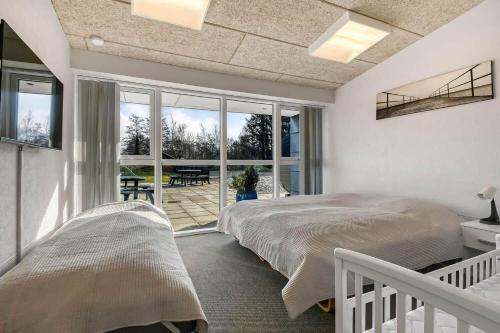a bedroom with two beds and a balcony at C11694-Hemmet-Klydevaenget-1 in Hemmet