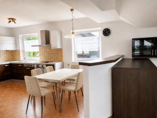 a kitchen with a white table and chairs at Alpine Forest Apartments in Radovljica