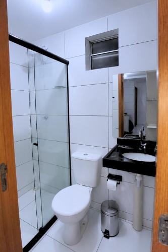 a white bathroom with a toilet and a sink at Apto Completo São João com Garagem e Piscina in Campina Grande