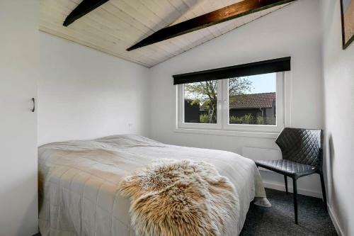 a bedroom with a bed and a chair and a window at C11348-Tarm-Laksestien-3 in Tarm
