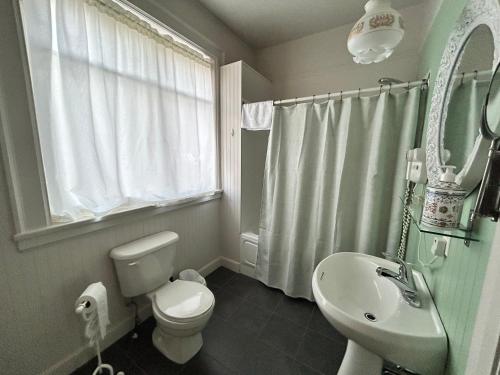 a bathroom with a white toilet and a sink at Auberge La Seigneurie in Matane