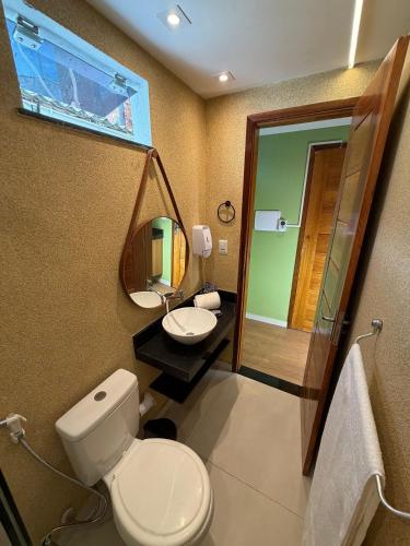 a bathroom with a toilet and a sink and a mirror at Studios Caripunas Reformado Localização Central in Belém