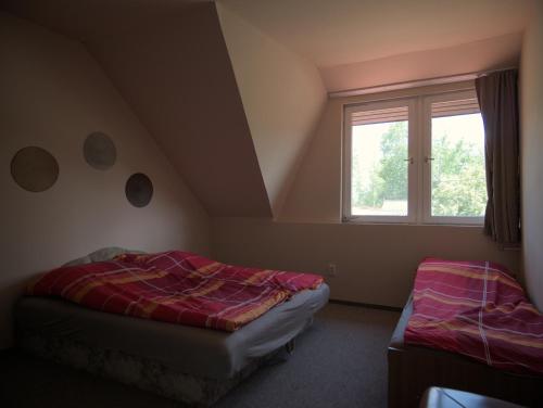 a bedroom with two beds and a window at Margaráta Vendégház in Soltvadkert