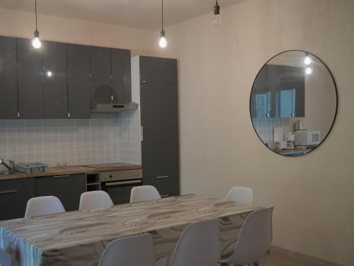 a kitchen with a table with chairs and a mirror at Margaráta Vendégház in Soltvadkert