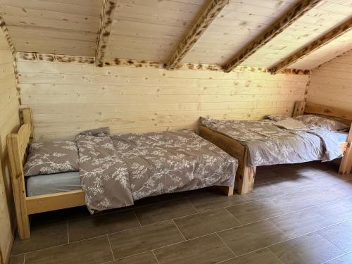 a room with two beds in a wooden cabin at Bungalow-Guest House Alpina in Vusanje
