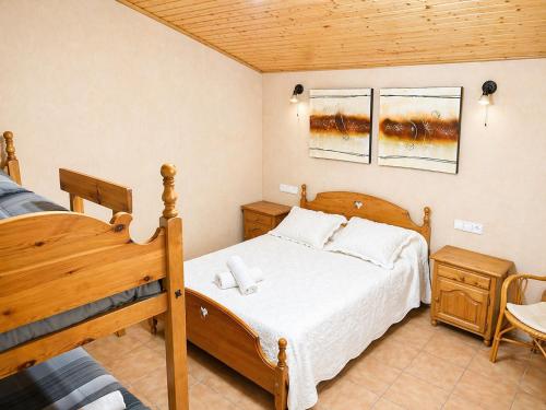 a bedroom with a wooden bed and a wooden ceiling at Masia Pau Prat in Lliçà d'Amunt