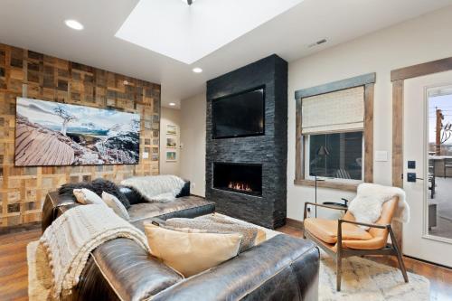 a living room with a leather couch and a fireplace at Central Loft 303 in Whitefish