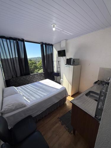 a bedroom with a bed and a desk and a computer at Lindo Apto Mobiliado, Smart TV - Caieras in Caieiras
