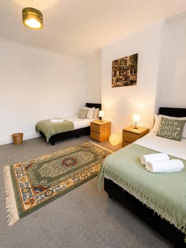 a room with two beds and a rug at Ushaw HillTop View-Suburban Free Parking Ideal for Work-Stays & Families in Ushaw Moor