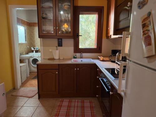 a kitchen with wooden cabinets and a sink and a refrigerator at Like a local in Chios Castle in Chios