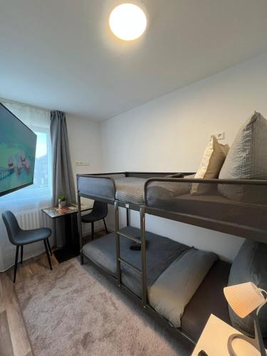 a bedroom with a bunk bed and a desk at City Hub Room 27 - Coffee for free - in Karlsruhe
