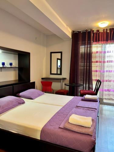 a bedroom with two beds and a table and chairs at Adzija House in Ohrid