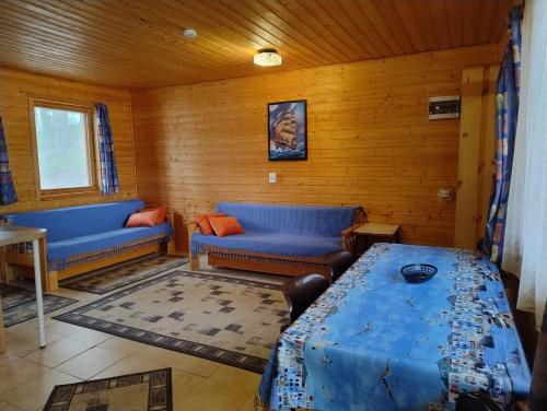a living room with blue couches and a table at Lomasaaret Cottages in Villala