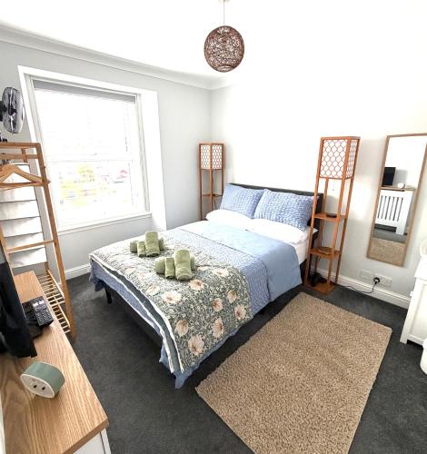a bedroom with a bed and a ladder and a window at Joshua House in Newquay