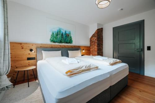 a bedroom with a large white bed with a green door at Frisch sanierte Wohnung mit zwei Schlafzimmern in historischem Baudenkmal in Feldberg