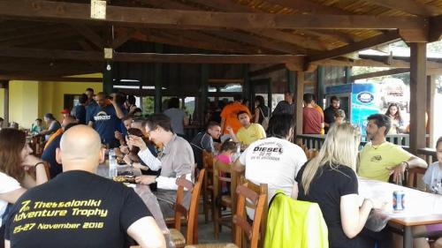 a crowd of people sitting at tables in a restaurant at Pangeo forest village in Mousthéni