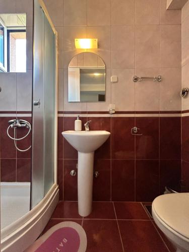 a bathroom with a sink and a shower and a toilet at Adzija House in Ohrid