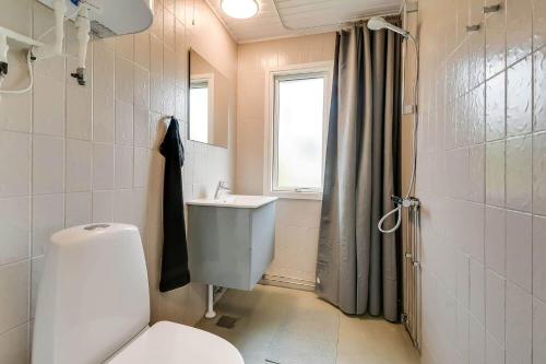a bathroom with a toilet and a sink and a window at C11347-Tarm-Baeverstien-8 in Tarm