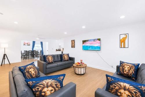 a living room with two couches and a table at The Golfstream Dunes Villa in Hallandale Beach