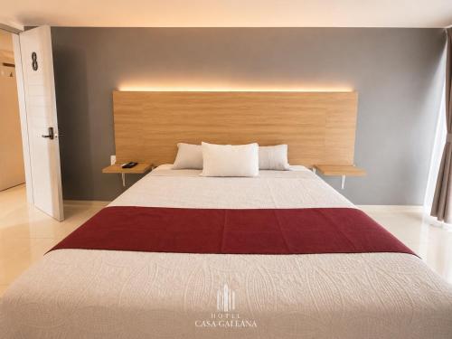 a bedroom with a large bed with a wooden headboard at Hotel Casa Galeana Centro con Estacionamiento Privado in Aguascalientes