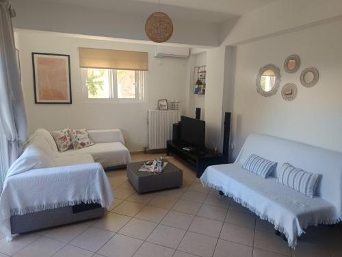a living room with two beds and a couch at Airport Anasta Casa in Artemida