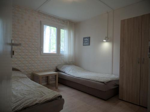 a bedroom with two beds and a window at Rózsa Villa Vadkerti tó in Soltvadkert