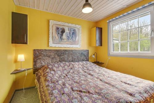 a bedroom with a large bed with yellow walls at C11712-Bork-Havn-Magevaenget-17 in Falen