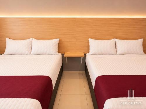 two beds sitting next to each other in a room at Hotel Casa Galeana Centro con Estacionamiento Privado in Aguascalientes