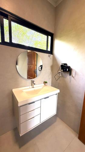 a bathroom with a sink and a mirror at Casa 03 suites Maragogi Japaratinga in Japaratinga