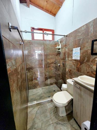 a bathroom with a shower and a toilet and a sink at Cabaña Florez in Santa Marta