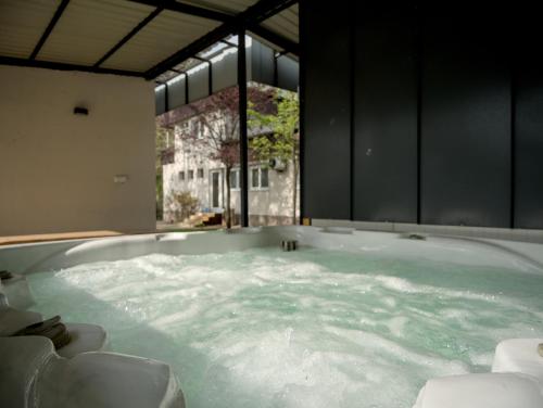 a large bath tub filled with water in a room at Rózsa Villa Vadkerti tó in Soltvadkert