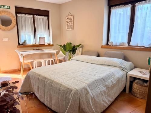 a bedroom with a bed and a table and chairs at Monte Subiedes, Apartamentos Valle de Camaleño in Camaleño