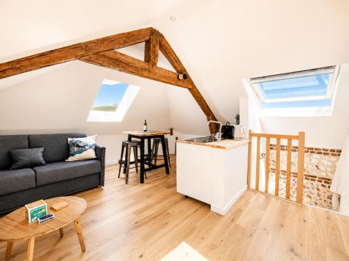 a living room with a couch and a table at Le bleu infini - vue mer, falaises, centre ville in Étretat