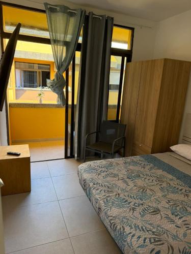 a bedroom with a bed and a window with a chair at Urban Stay Maspalomas in San Bartolomé