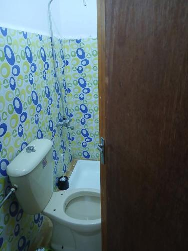 a bathroom with a toilet and a shower curtain at Lovely hotel in Al Qābūţī