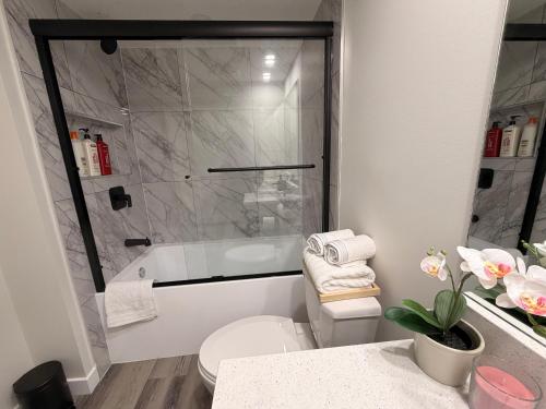 a bathroom with a shower and a toilet and a sink at Eden Secret YYC in Calgary